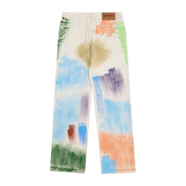 Postrzępione, luźne, niebieskie jeansy z efektem tie-dye i malowaniem. Prane, casualowe, idealne do codziennego noszenia.