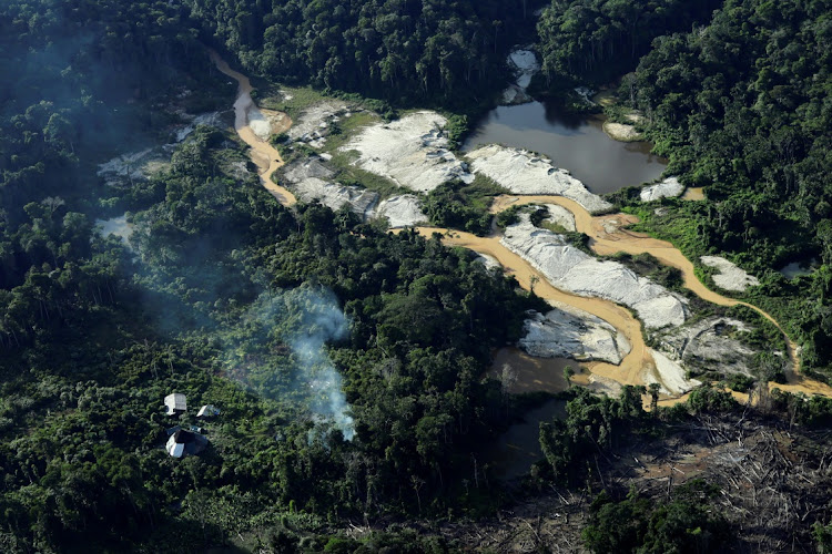 An illegal mine surrounds Yanomami Indigenous huts. Picture: UESLEI MARCELINO/REUTERS