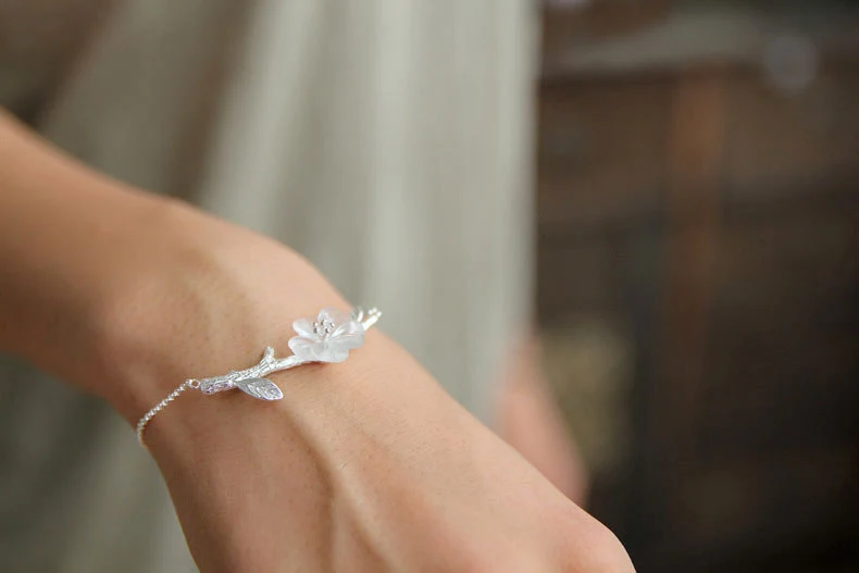 Pulseira feminina de prata esterlina com flor de cristal branco entalhada à mão, elegância e beleza.