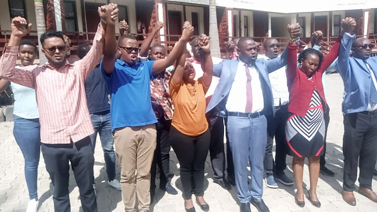 Kenya Medical Practitioners, Pharmacists and Dentists Union officials hold hands in solidarity before addressing the press at Elementaita in Gilgil area of Nakuru County.