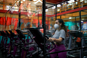 A member exercises on a machine fitted with plastic panels to ensure safe distance among gym goers, at Bally Sport Center, after a five-month quarantine, amid the coronavirus disease pandemic, in Antiguo Cuscatlan, El Salvador September 7 2020. 
