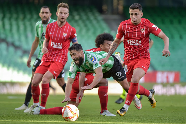 Real Betis' French midfielder Nabil Fekir (C) tumbles during the Spanish Copa del Rey (King's Cup) round of 16 first leg match between against Sevilla FC at the Benito Villamarin Stadium