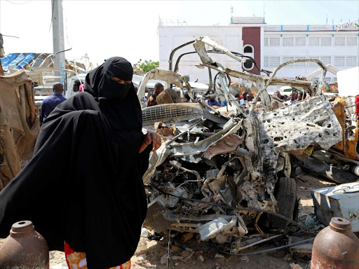 A Somali walks past the wreckages of vehicles destroyed during a suicide bomb attack near the Sahafi hotel in Mogadishu, Somalia November 10, 2018. REUTERS/Feisal Omar