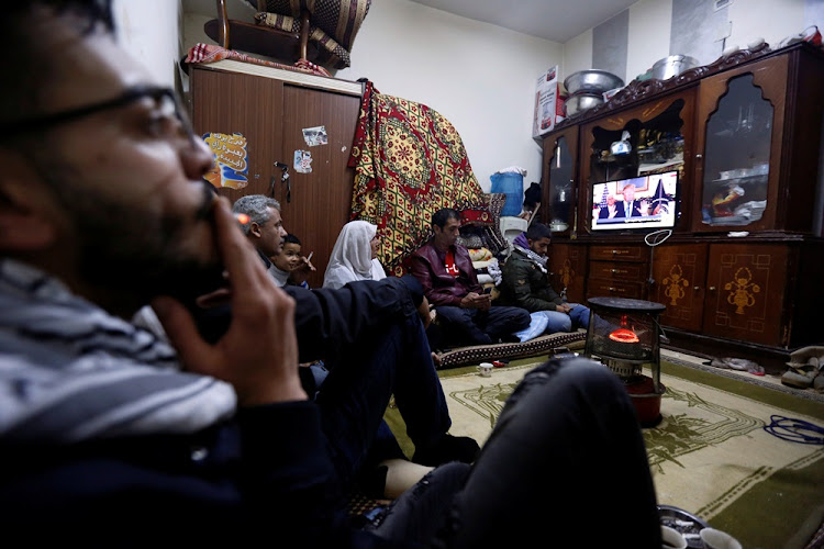 Palestinian refugee family watches a televised broadcast of U.S. President Donald Trump delivering an address where he announced that the United States recognises Jerusalem as the capital of Israel, at Al-Baqaa Palestinian refugee camp, near Amman, Jordan December 6, 2017.