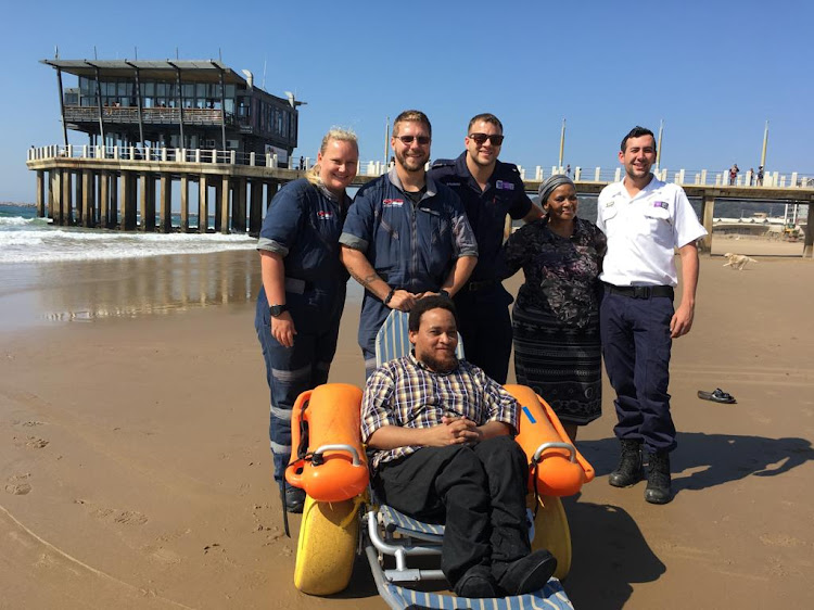 Sibusiso Zondi, his mother Zamajali Ngcobo, and members from Life Response help Zondi get his feet wet.