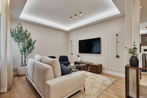Modern living room with beige sofa and TV stand in this luxury property for sale in Madrid ($1,479,571 - 80 m²)