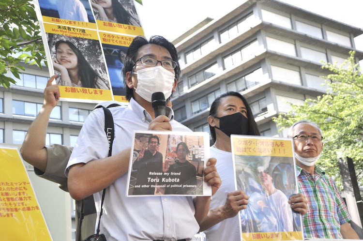 Japanese journalist Yuki Kitazumi, who was detained and freed in Myanmar in 2021, shows off a photo of Japanese documentary filmmaker Toru Kubota who is believed to have been detained in Myanmar after filming a protest that took place on July 30, 2022, outside the Foreign Ministry in Tokyo, Japan on July 31 2022. Picture: KYODO via REUTERS