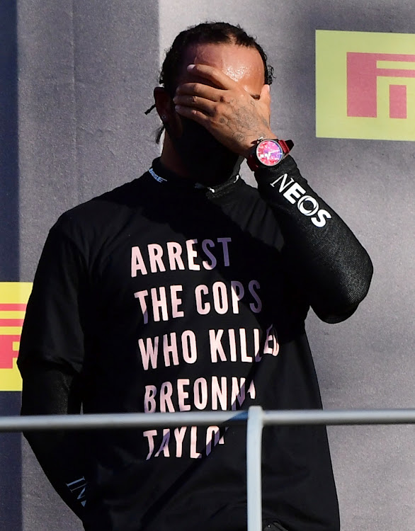 Mercedes' Lewis Hamilton wears a shirt in reference to Breonna Taylor on the podium as he celebrates after winning