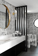 The monochromatic guest bathroom is enveloped in Romo's Itsuki wallpaper.