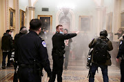 Supporters of US President Donald Trump set off a fire extinguisher after breaching security defences, as police move in on the demonstrate on the second floor of the US Capitol near the entrance to the Senate, in Washington, US, on January 6, 2021.