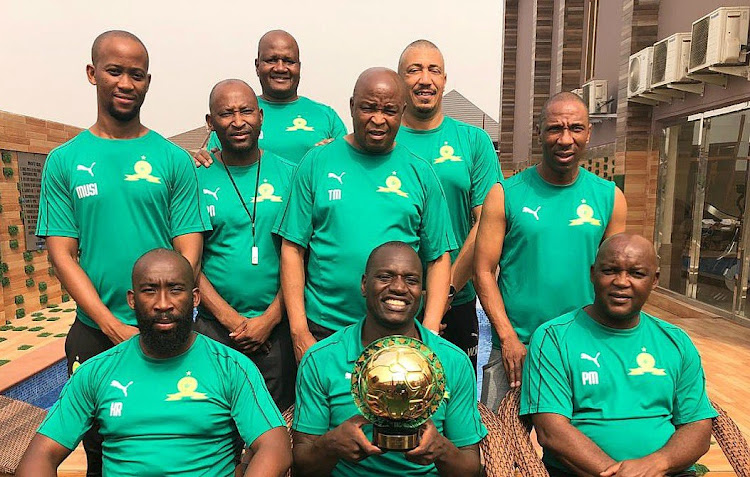 Mamelodi Sundowns goalkeeper Denis Onyango holds his Caf award trophy surrounded by his technical team.
