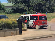 Sinthamone Ponnan is escorted into an ambulance outside the Durban magistrate's court.