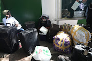 A Nigerian womanwaits outside the Nigerian embassy in Rivonia hoping to get free transport to take her home