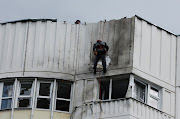 Workers repair damage on the roof of a multi-storey apartment block after a reported drone attack by Ukraine in Moscow, Russia on May 30 2023. File photo. 