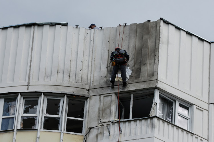 Workers repair damage on the roof of a multi-storey apartment block after a reported drone attack by Ukraine in Moscow, Russia on May 30 2023. File photo.