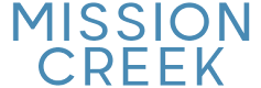 "Logo with the text 'Mission Creek' in bold blue letters, evoking a modern and stylish apartment complex."