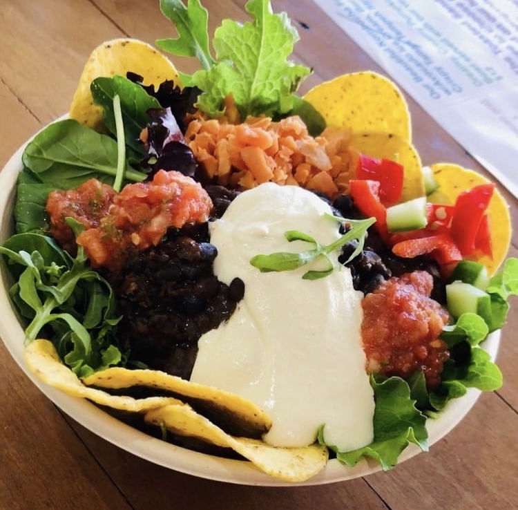 Taco Salad Bowl with Slow cooked Chipotle Black Beans, Creamy Garlic Sauce, Salsa and fresh and Fermented Salads. Served with local made totopos.