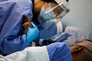 A mental health worker with Doctors Without Borders (MSF) attends to a patient who has the coronavirus disease (Covid-19) at a hospital where the organization is helping address mental health challenges faced by patients with the disease, in Caracas, Venezuela February 1, 2022. Picture taken February 1, 2022.