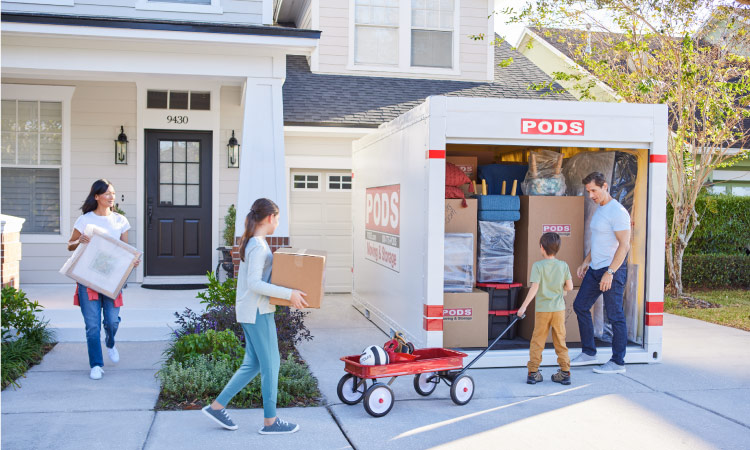 A family of four is loading their PODS portable moving container as they prepare for their move to Chicago.