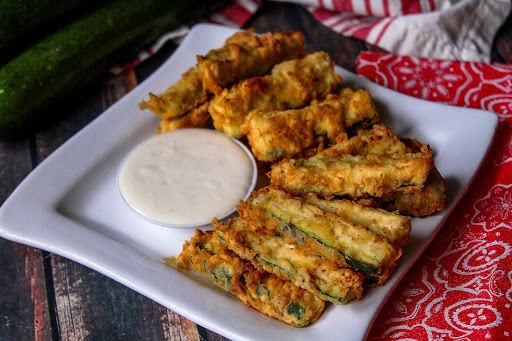 A plate of Fried Zucchini with dipping sauce.