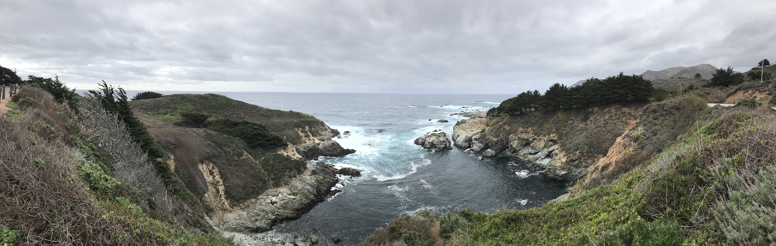 beautiful ocean cove in california surrounded by green hills and calm water in california