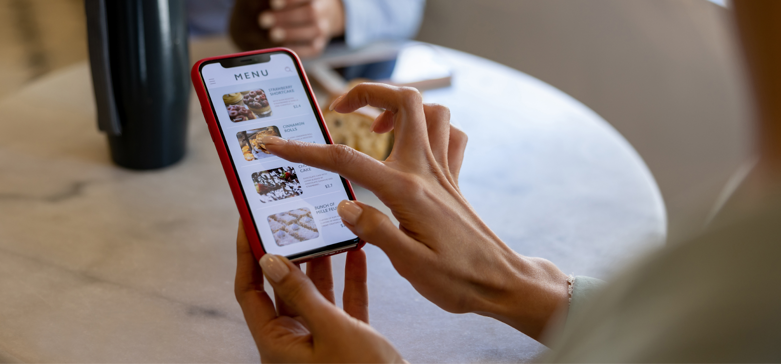 a woman selecting a menu using the QR codes provided by the restaurant