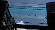 Residents swim in the Embassy Gardens Sky Pool, a transparent acrylic swimming pool suspended between two buildings in London, on May 27, 2021.