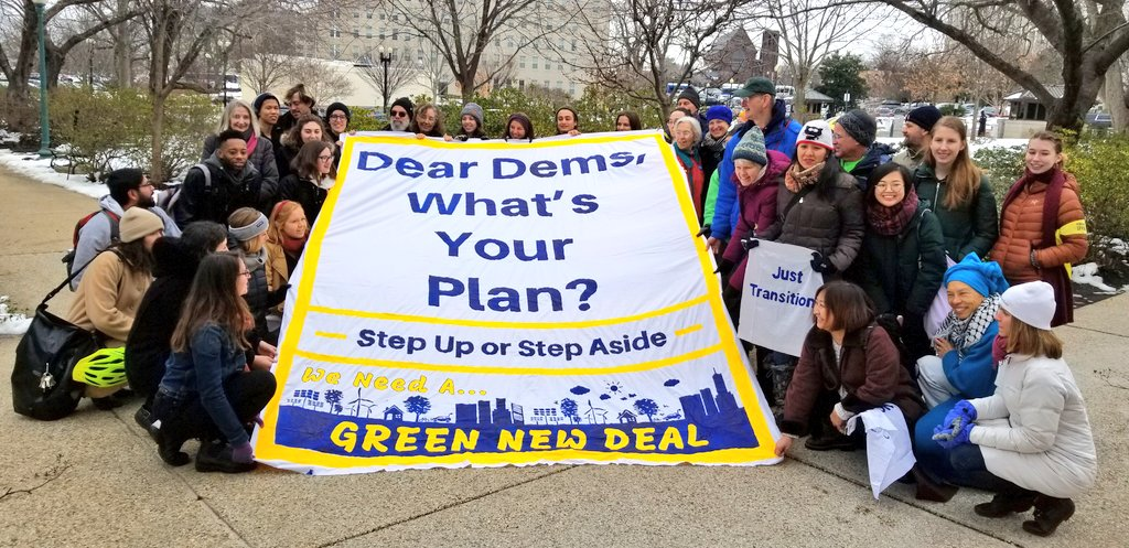 Emily and our team with the banner after the action at Sen Schumer's office