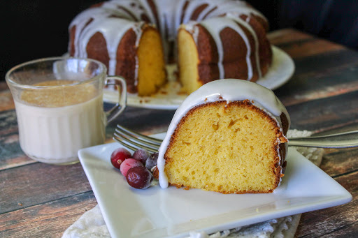 Eggnog cake with rum frosting sliced and on a plate.