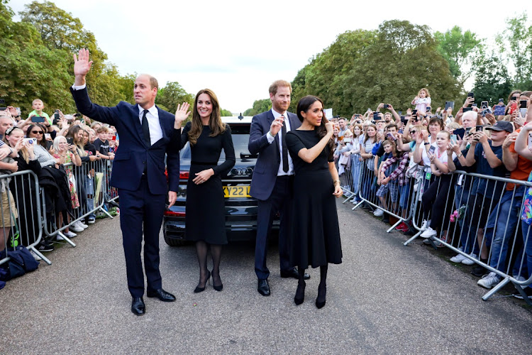 Catherine, Princess of Wales, Prince William, Prince of Wales, Prince Harry, Duke of Sussex, and Meghan, Duchess of Sussex wave to crowd on the long Walk at Windsor Castle on September 10, 2022 in Windsor, England.