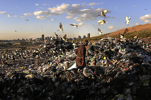 A waste picker makes his way through a Johannesburg dumping site. File photo