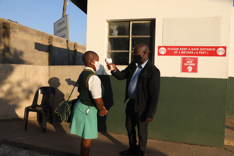 Pupils' support agent Mthobisi Nxumalo screens pupils at Sibusisiwe Comprehensive Technical School in Umbumbulu.