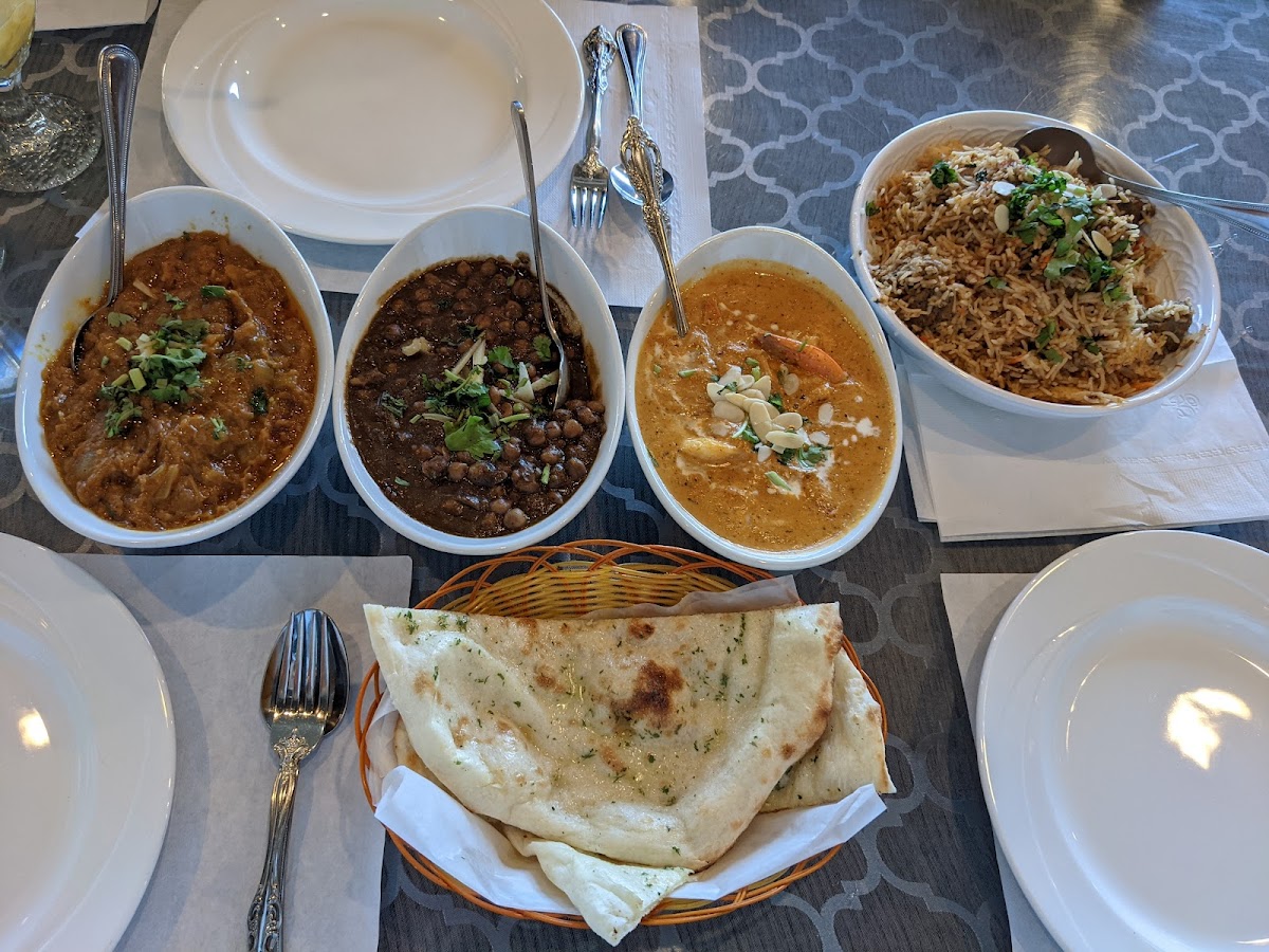 clockwise from top left: eggplant, chana masala, shrimp korma, beef Biryani, glutenous garlic naan