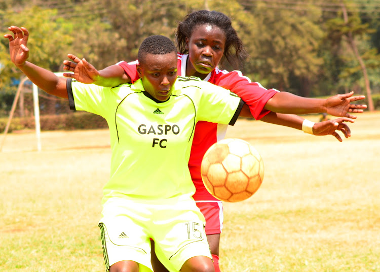 Gaspo's Wincate Kaari shields the ball from Catherine of Kibera girls during their FKF Women premier league match at Stima club,Ruaraka on July 14,2019