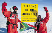 Nzuzo Mnikathi, right, and Iain Buchan, founder of the Unlimited Child organisation, fly the South African flag shortly after reaching the South Pole in the early hours of Sunday Picture: SEAN WISEDALE