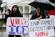 Demonstrators Madvhi Venkatraman and Gabi Huesca listen to the cries of illegal immigrant children held in a US detention facility after being separated from their parents that Venkatraman is playing through her megaphone during a protest against the separation of immigrant families outside the White House in Washington, US, June 22, 2018. 