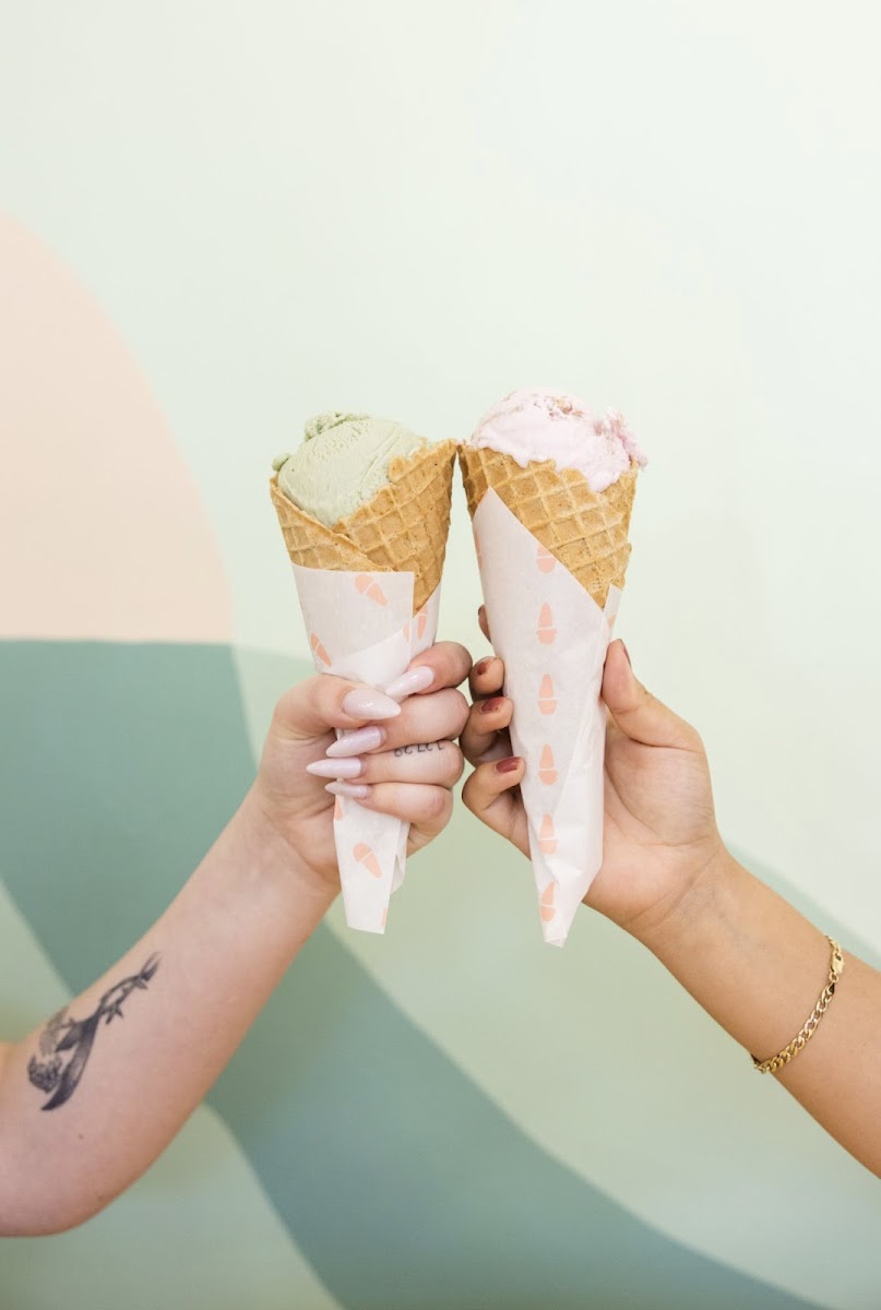 Two friends holding Kate's Ice Cream scoops in waffle cones.