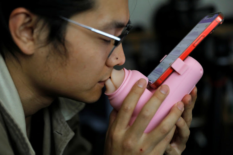 Jing Zhiyuan uses a remote kissing device "Long Lost Touch", as he demonstrates for camera how to use it during an interview with Reuters, at his home in Beijing, China March 12, 2023.