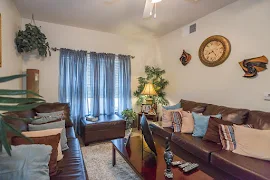 Living room with neutral carpet, white walls, window with blinds