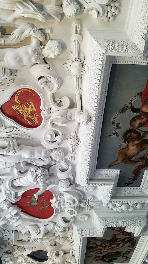 Visiting Rosenborg Castle in Copenhagen. This is the Marble Room - the ceiling paintings also show small, chubby, angelic child figures, carrying the Regalia and in the heart-shaped areas surrounding the paintings you can see parts of the Danish coat-of-arms and on the wall are the emblems of Norway, Denmark, and Sweden.