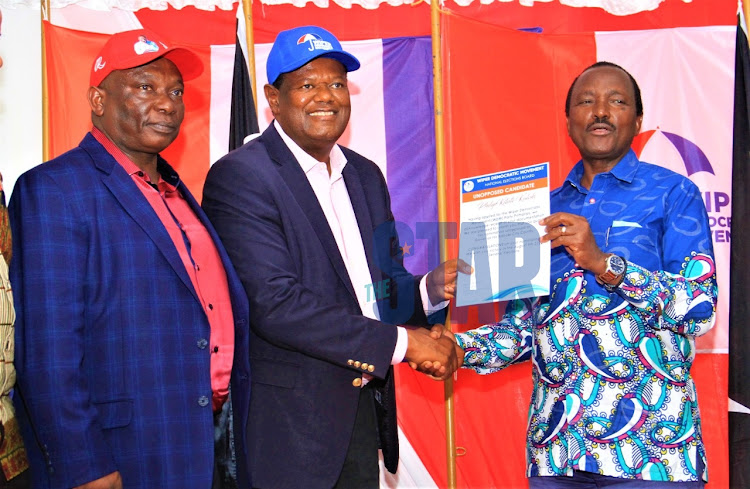 Nairobi County gubernatorial aspirant Richard Ngatia looks as Philip Kaloki receives his certificate from Wiper leader Kalonzo musyoka to go and negotiate with Ngatia on who to deputise the other at SKM Command centre on April15, 2022.