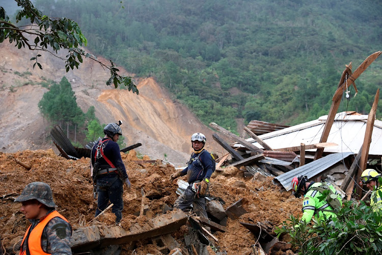 Rescue workers inspect an area hit by a mudslide caused by Storm Eta, as the search for victims continues in Queja, Guatemala on November 7 2020.