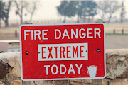 A sign indicating extreme fire danger is pictured outside Storrie Lake State Park as the Hermits Peak and Calf Canyon wildfires burn near Las Vegas, New Mexico, US on May 2, 2022. 
