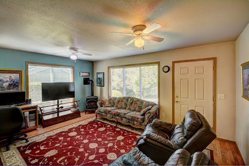 Living room with floral sofa and stove - Buy this luxury house in Cannon Beach, 3 bedrooms