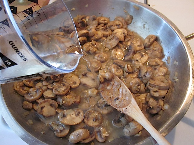 chicken broth and wine added to mushroom roux in pan 