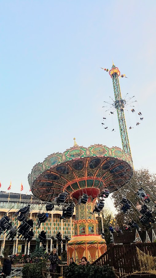 The Star Flyer is the high swing carousel ride in the back right, and the the Swing Carousel to the left from 1907 used at Halloween and Christmas / Visiting Tivoli Amusement park during Halloween decoration time, October 2018