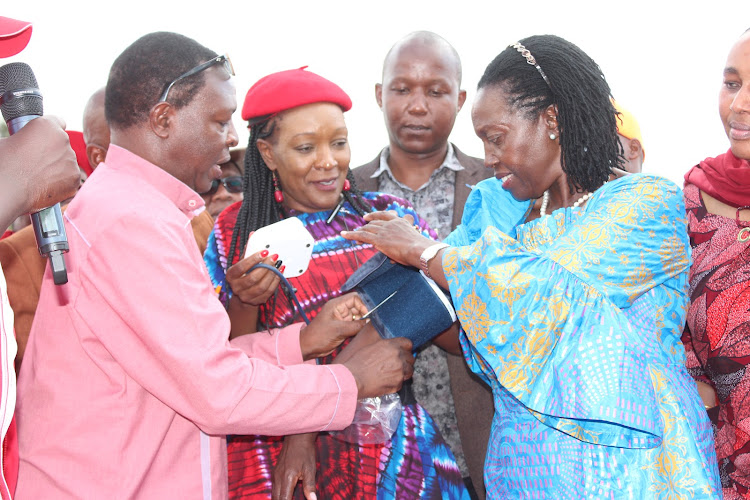 County Community Health Officer Stephen Kuria using a blood pressure machine on Martha Karua on June 11