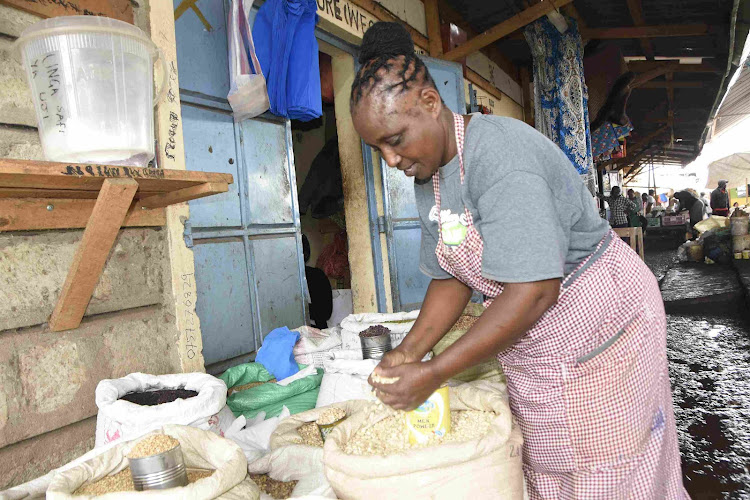 Emily Karanta, a cereals trader at Isiolo main market showcases how she measures grain.