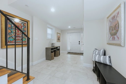 Entrance with staircase and decorative paintings in this luxury house for sale in Long Beach ($1,399,999)