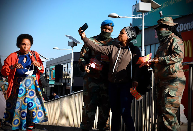 A Soweto commuter takes a selfie with soldiers on patrol at the Baragwanath taxi rank on April 23 2020. The soldiers checked for permits and enforced lockdown regulations.